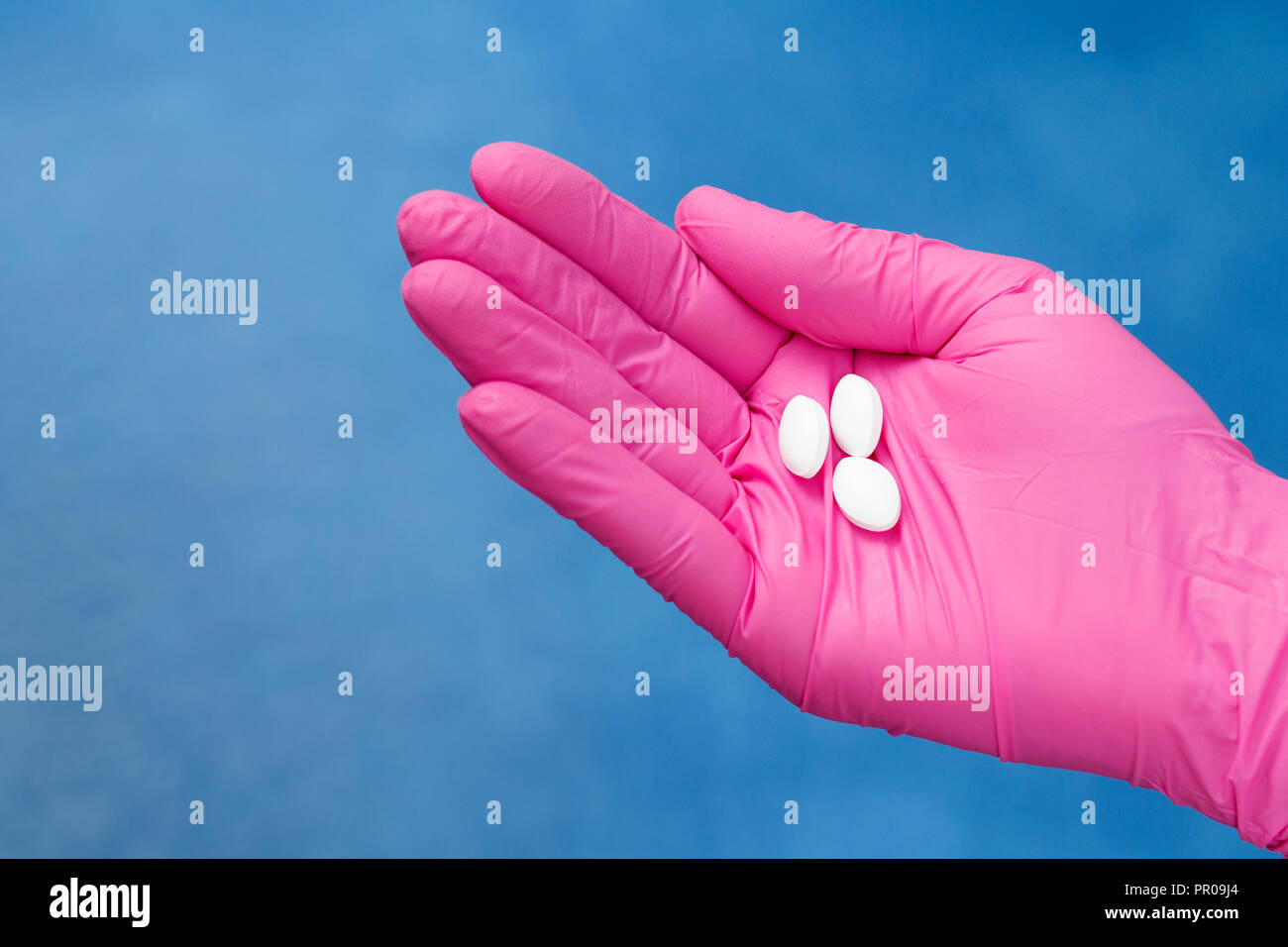 Le mani del medico donna in rosa con guanto di pelo bianco di pillole. Legal drug store concept Foto Stock