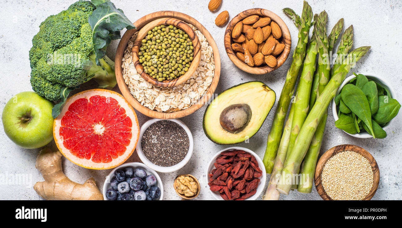 Superfoods sulla pietra di luce sullo sfondo. Sano cibo vegan. Foto Stock