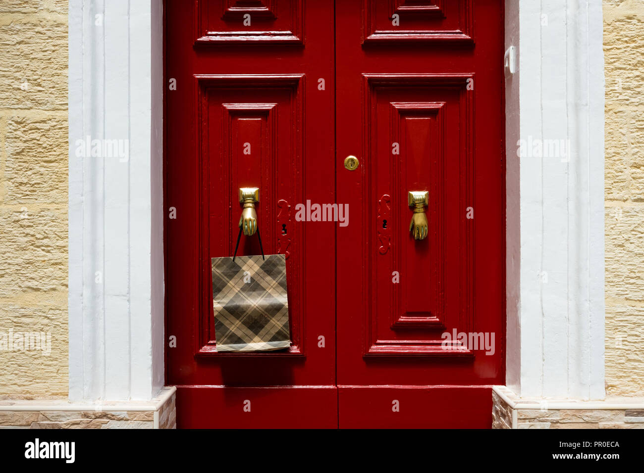 Borsa appesa al pomello della porta a forma di mano, a Malta. Foto Stock