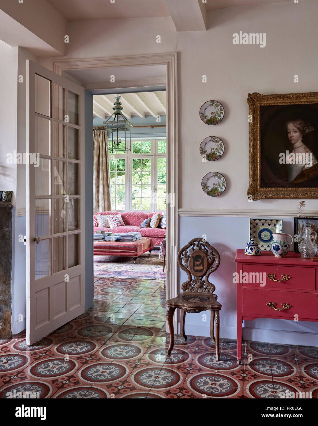 Armadio dipinto e scolpito vintage sedia con decorativo pavimento piastrellato ad aprire la porta Foto Stock