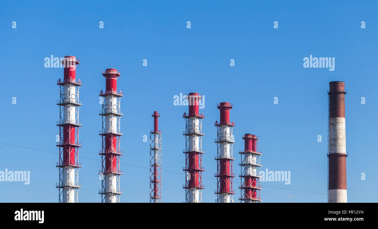 Rigato bianco rosso camini industriali oltre il cielo blu Foto Stock
