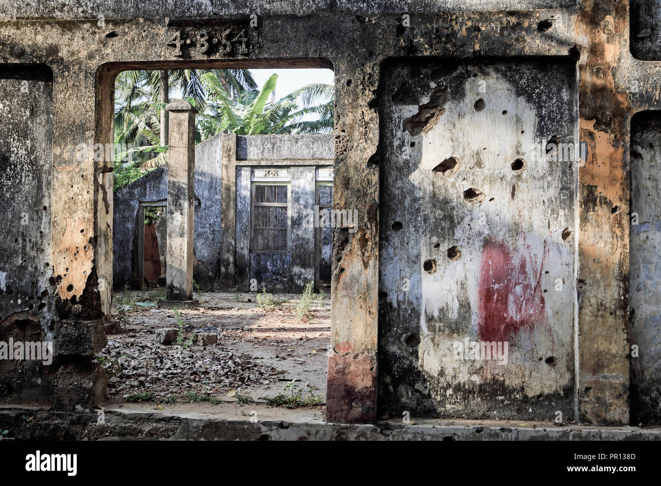 Il vecchio edificio in cemento, coperte in fori dal fuoco di mitragliatrici da Sri Lanka la guerra civile a Jaffna, Sri Lanka Foto Stock