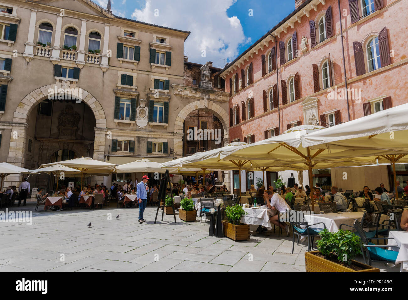 Piazza dei Signori, con la folla di mangiare in ristoranti di fronte a Palazzo Domus Nova sulla sinistra e Casa della Pietà sulla destra, Verona, Veneto, Italia Foto Stock
