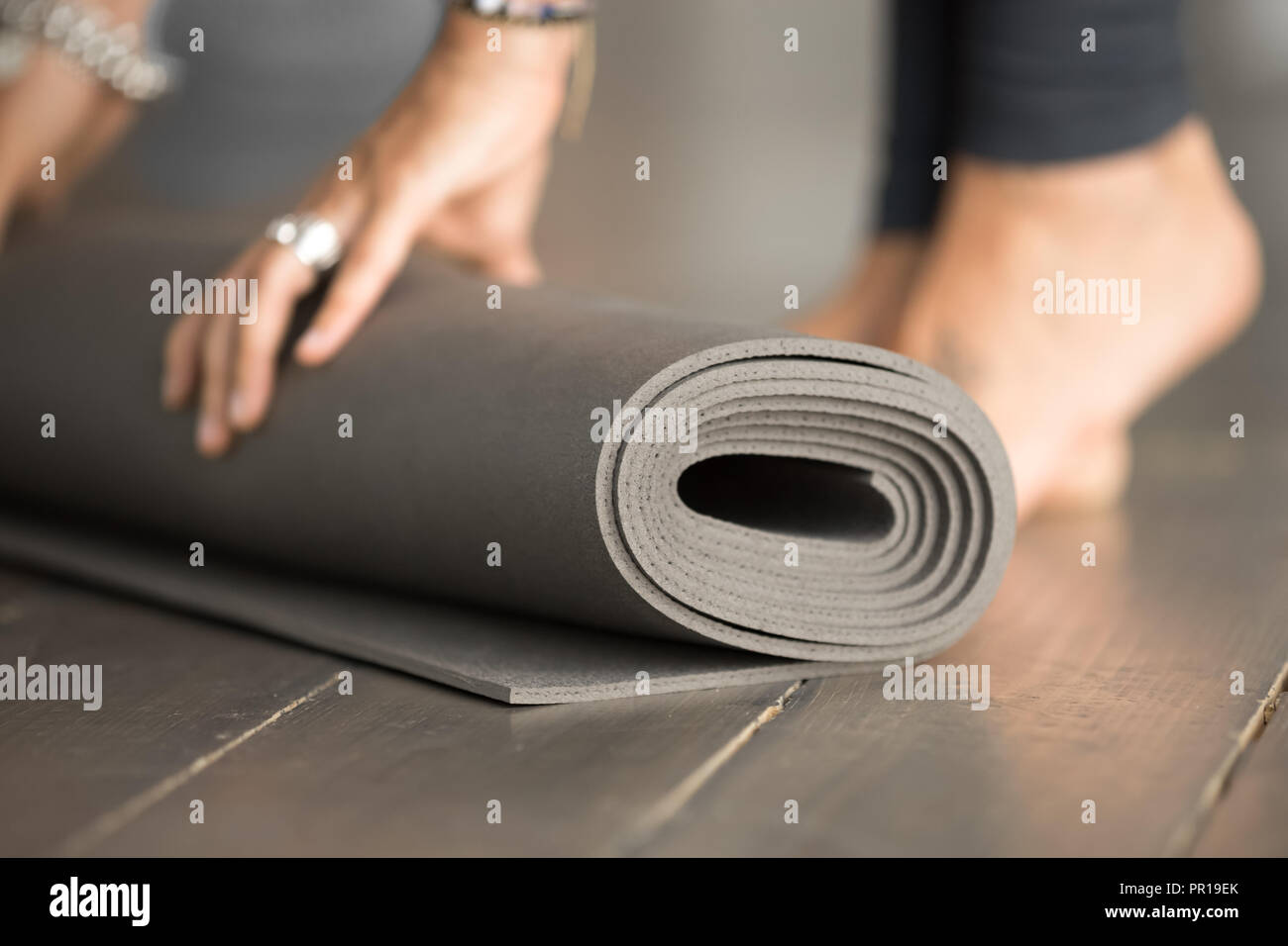 Ragazza di colore grigio di svolgimento esercizio fitness mat per classe, close up Foto Stock