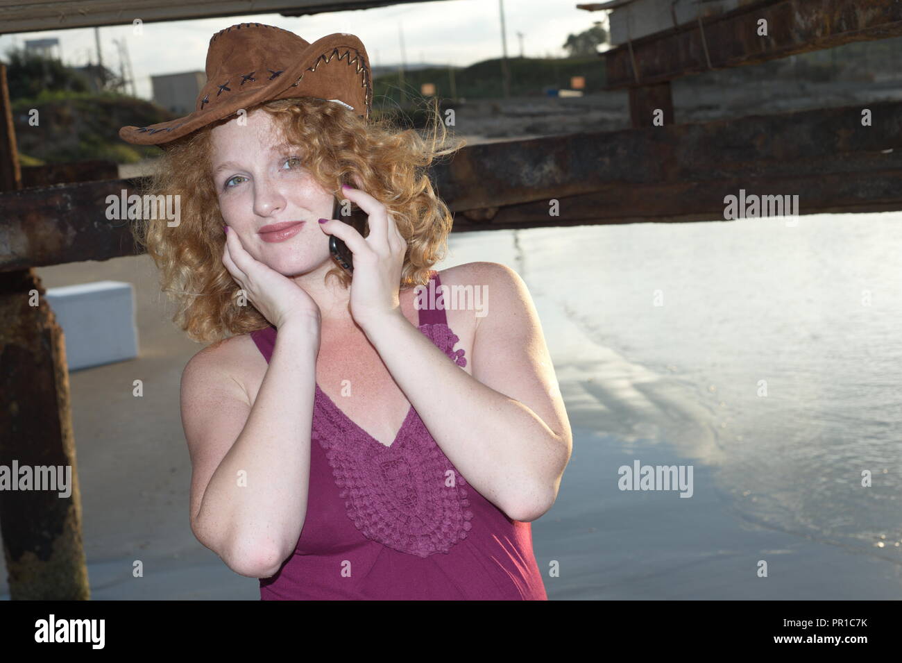 Incredibile redhead lady parla al telefono, sulla costa, il mare Foto Stock