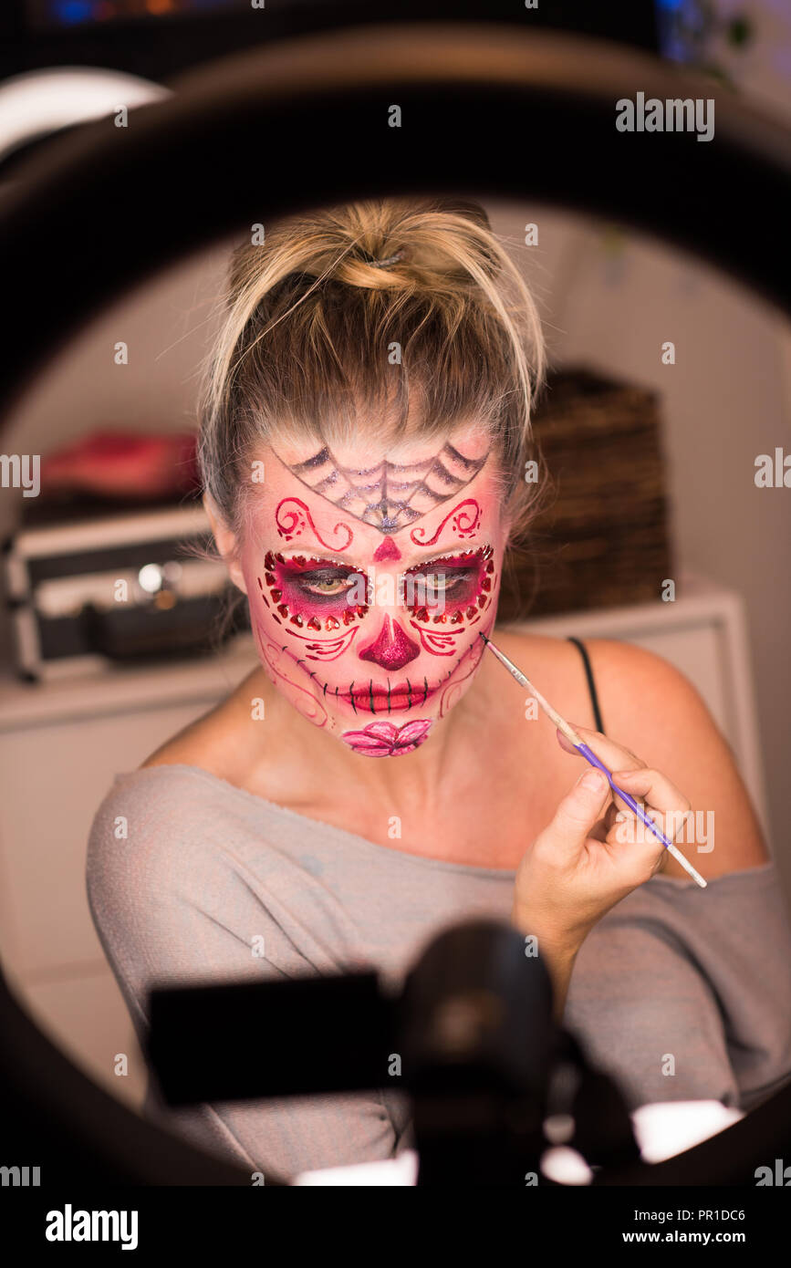 Donna dipinto il suo volto con spazzola Foto Stock