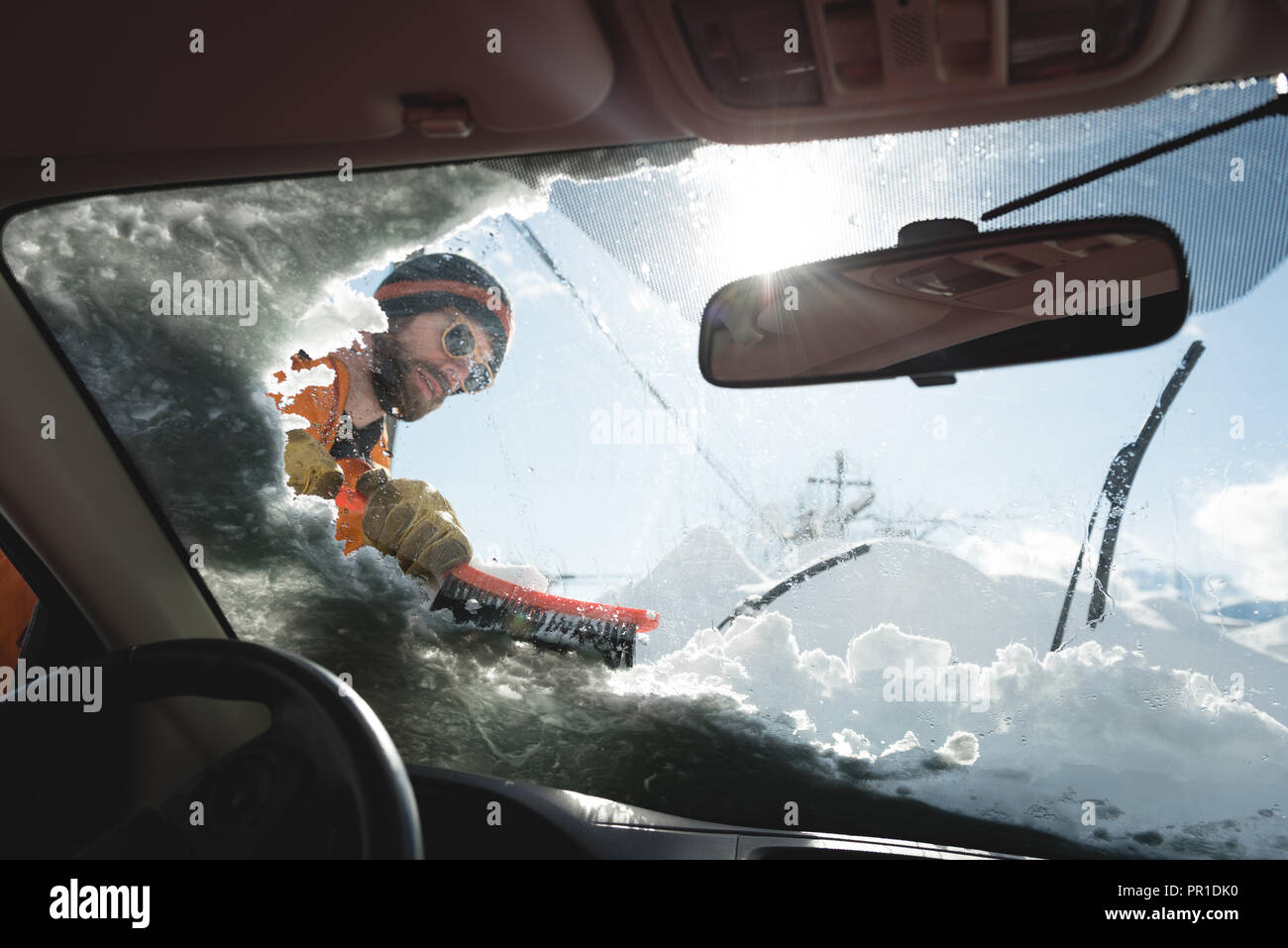 Uomo di neve di pulizia dal parabrezza per auto Foto Stock