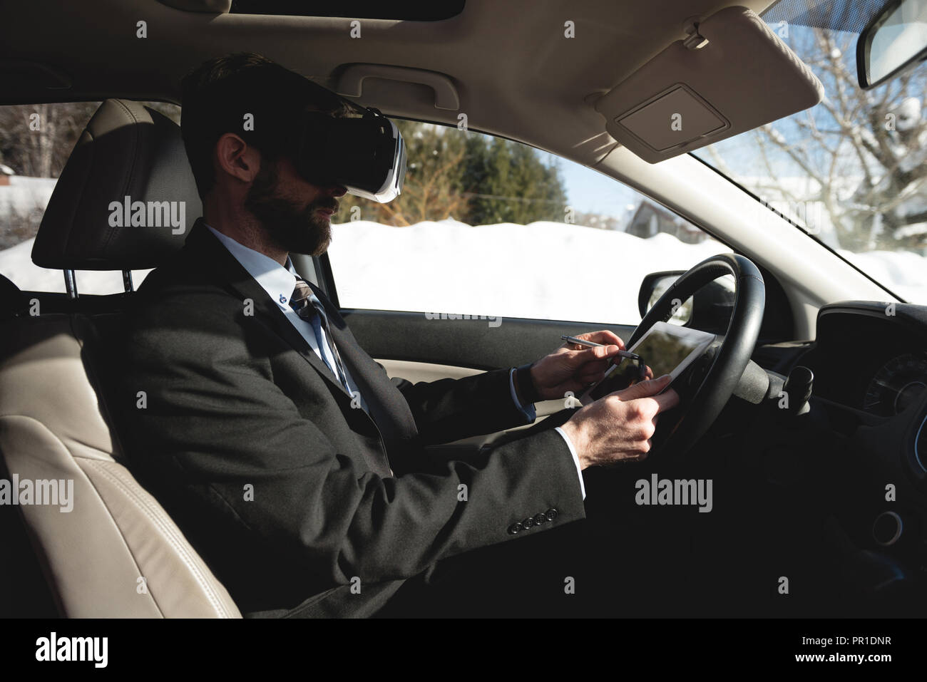 Imprenditore utilizzando la realtà virtuale auricolare con tavoletta digitale Foto Stock