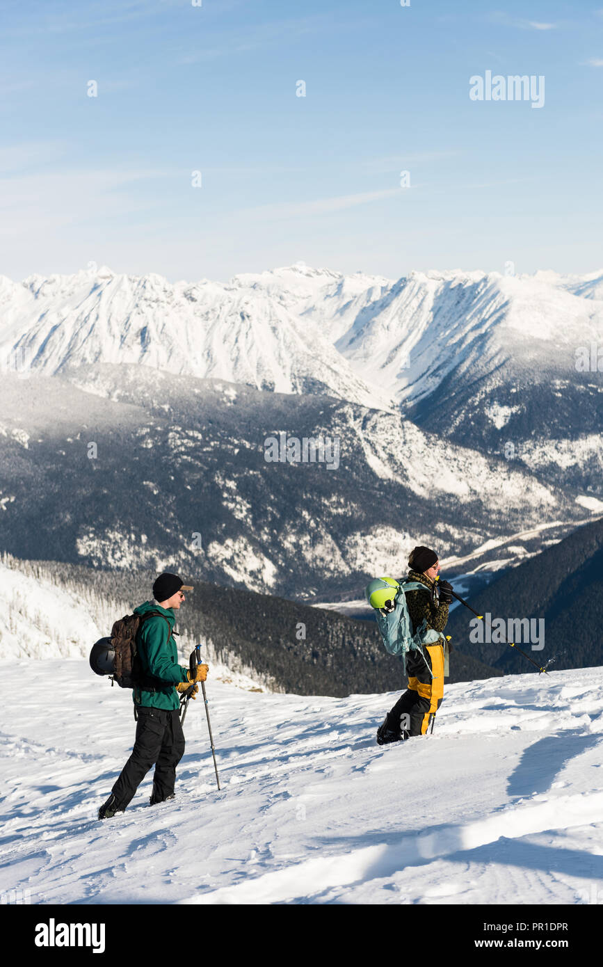 Maschio e femmina gli sciatori a camminare su una montagna innevata Foto Stock