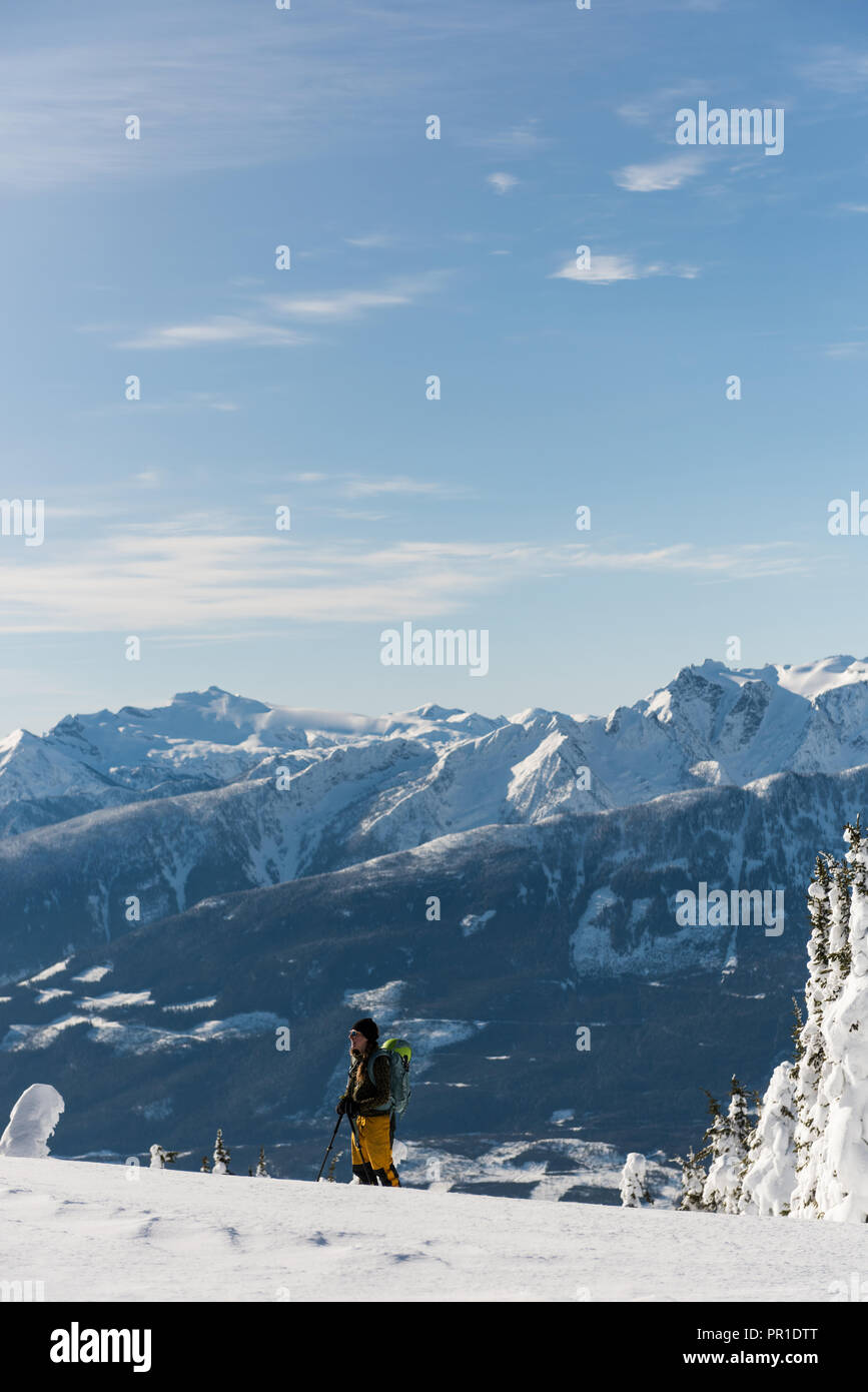 Sciatore femmina a camminare su una montagna innevata Foto Stock