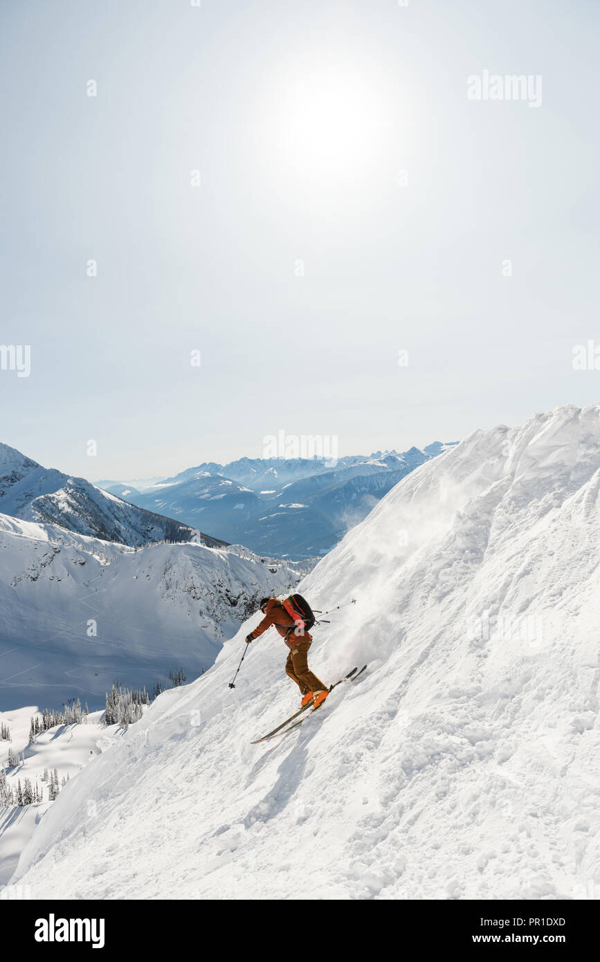 Sciatore di sciare su una montagna innevata Foto Stock