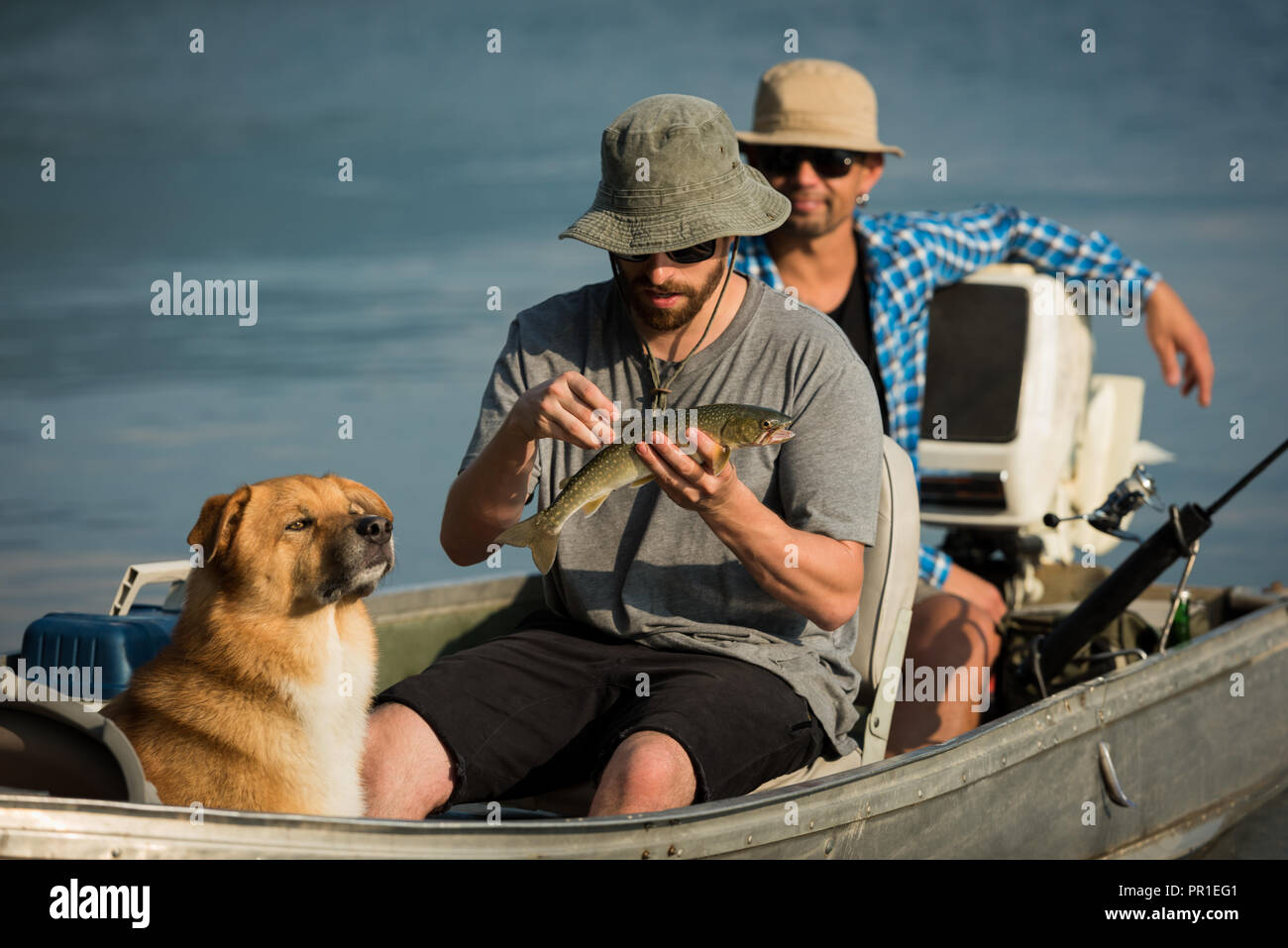 Fisherman tenendo un pesce sulla barca Foto Stock