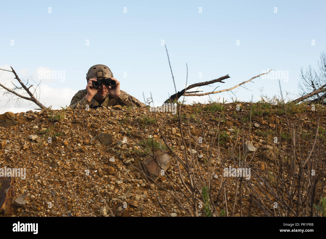 Militare guardando attraverso il binocolo Foto Stock