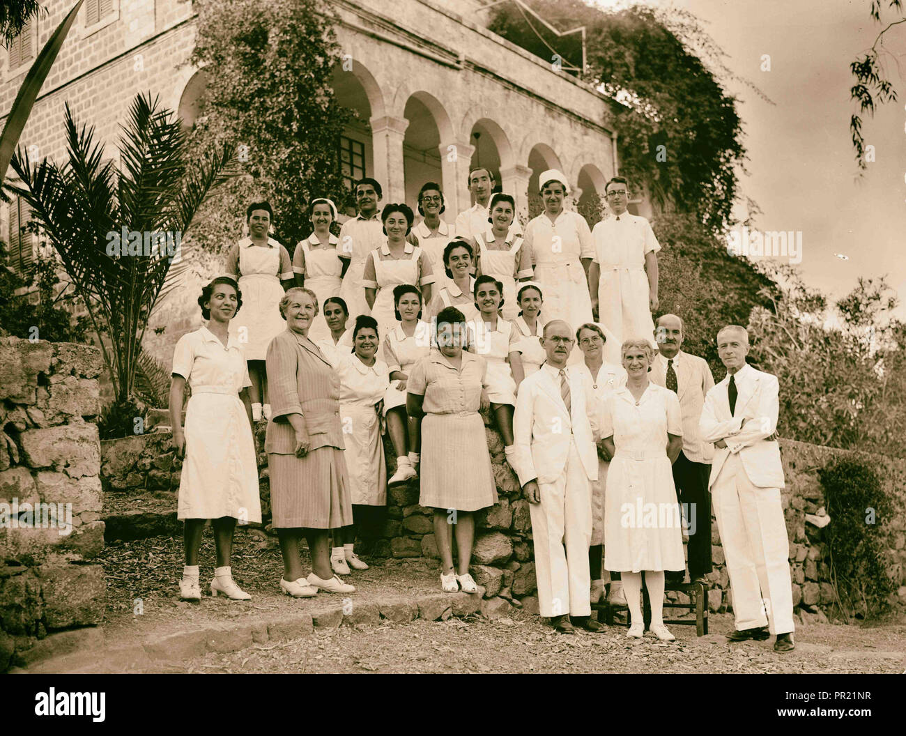 Il dott. H. Torrance, Tiberias. Gruppo. Il personale di casa Medici in background. 1940, Israele, Tiberias Foto Stock