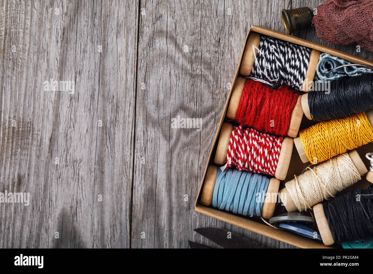 Bobine multicolori con filettature e strumenti per il lavoro di ricamo con copia spazio, vista dall'alto. Foto Stock