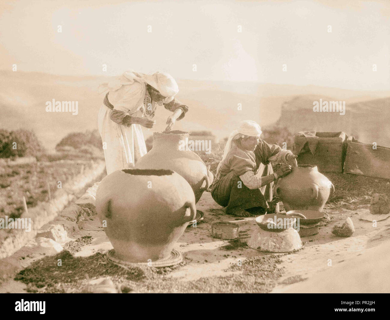 Agricoltura, donne contadine rendendo 'Zirs.' earthenwear grandi vasi. 1920, Medio Oriente, Israele e/o la Palestina Foto Stock