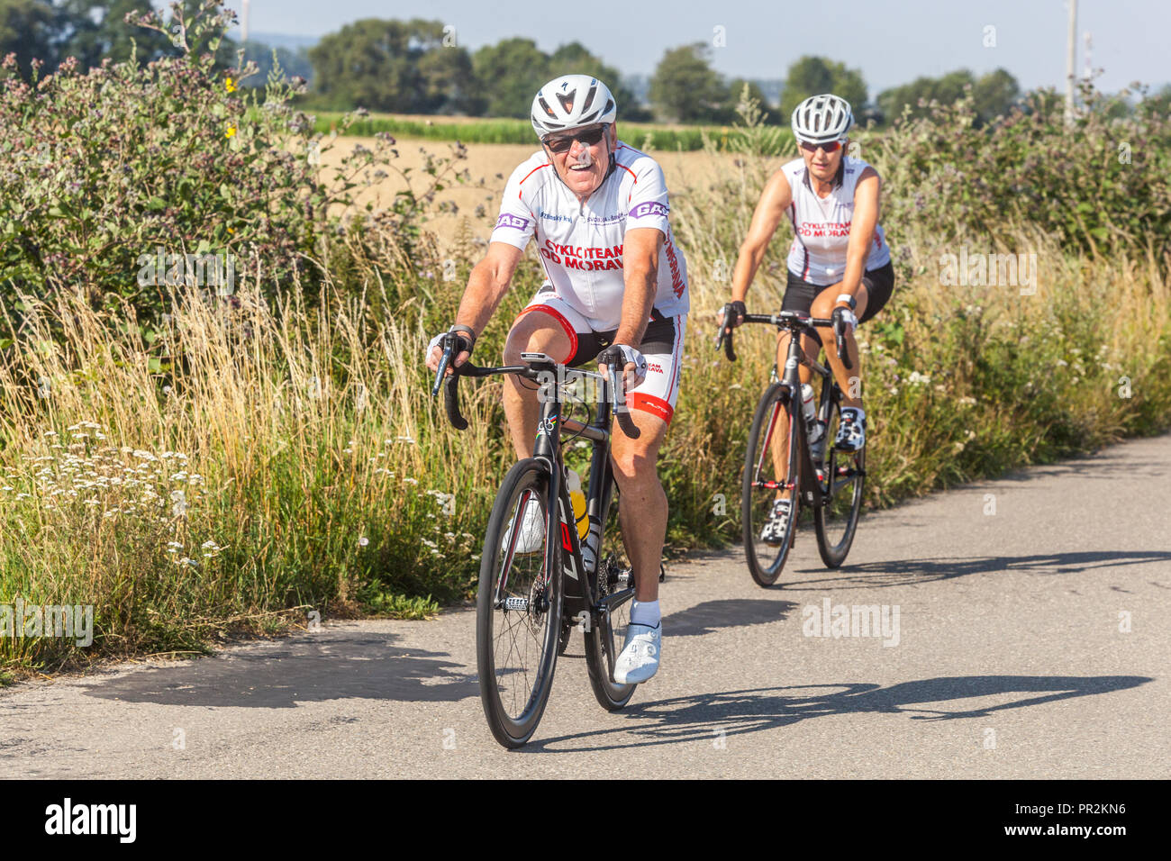 Invecchiamento attivo, coppia di due anziani in bicicletta attraverso la campagna, Repubblica Ceca sano stile di vita in bicicletta, mantenere il fitness Foto Stock