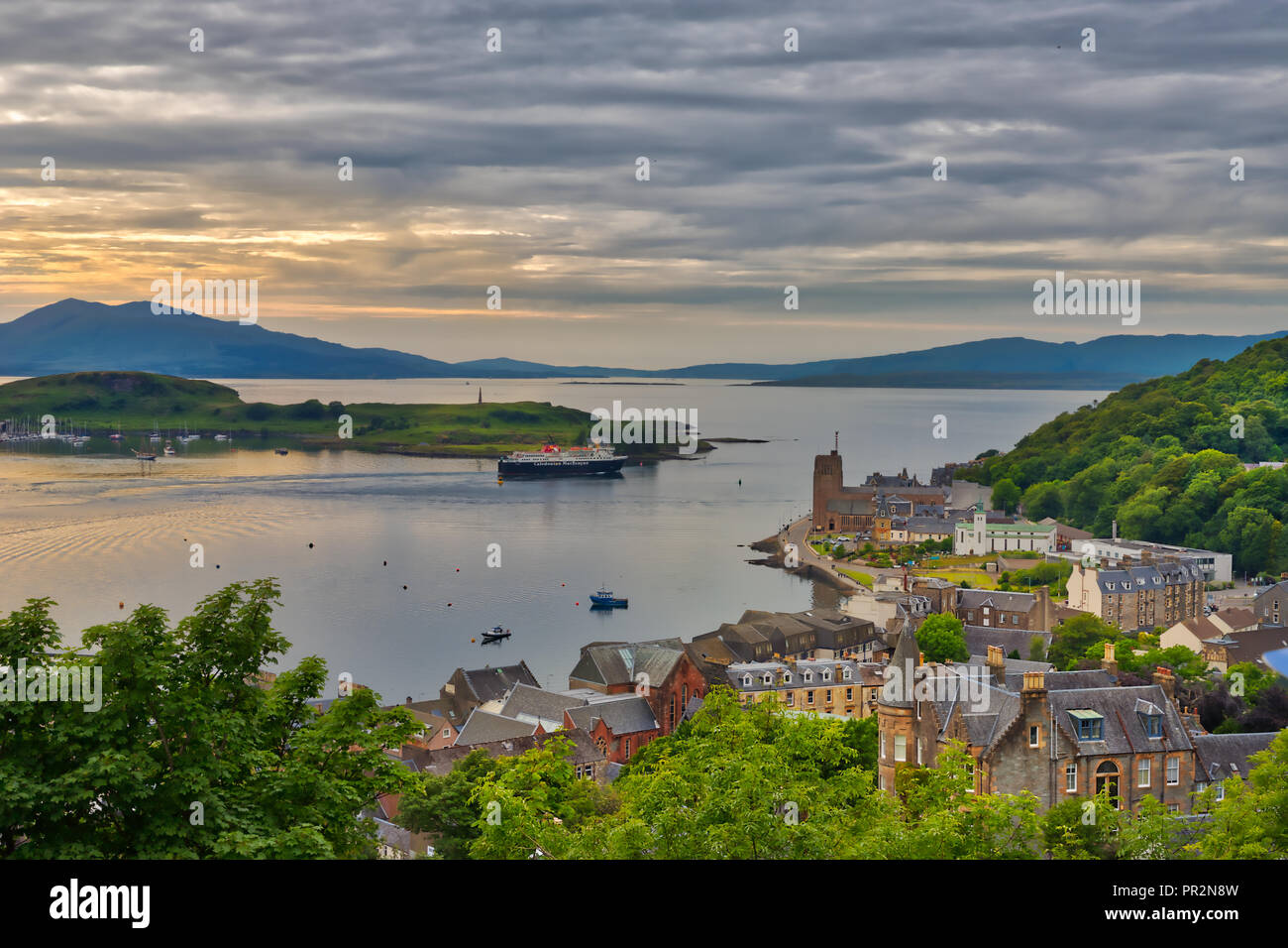 Un moody vista da una collina nella città portuale di Oban, Scozia guardando in giro per la città e l'acqua con l'Isle of Mull a distanza con un suggerimento di Foto Stock