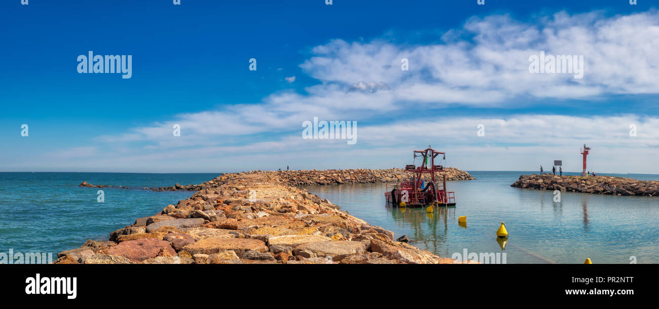 Panoramica diurna di sole guardando fuori all'ingresso a Port Saplaya con un luminoso cielo blu e acqua Foto Stock