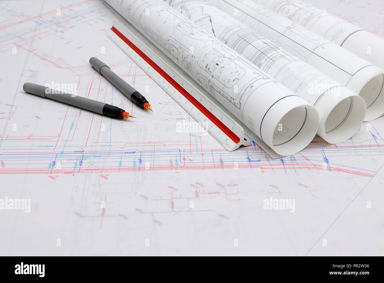 Arrotolata piani architettonici e utensili di disegno Foto Stock