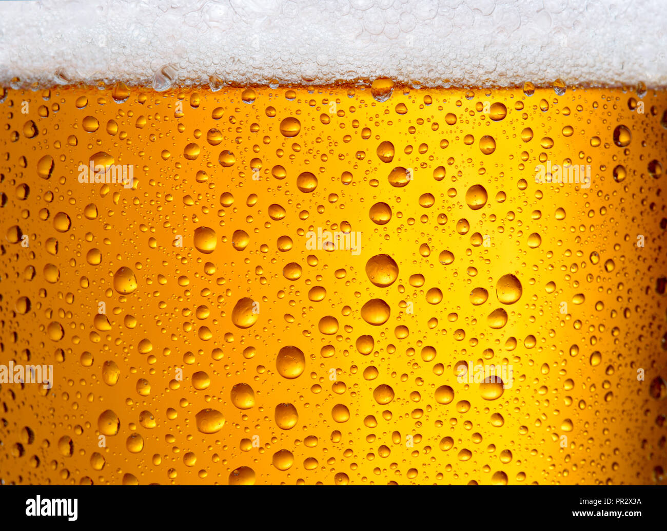 Vista ravvicinata di un bicchiere di birra con gocce e la schiuma come sfondo a trama Foto Stock