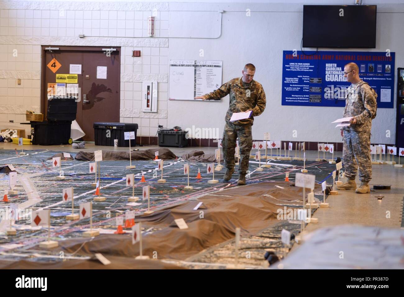 Fayetteville, North Carolina - Master Sgt. Joshua Chandler, un incendi operazioni sottufficiale, sinistra, e l'esercito Il Mag. Jamie Hicks, il fuoco Support Officer, entrambi con sede e Sede Società, trentesimo Armored Brigade Combat Team, effettuare un doppio controllo che essi hanno gettato i loro obiettivi in modo corretto sul modello del terreno a North Carolina National Guard Armory di Fayetteville, N.C, il 27 luglio 2017. Il modello del terreno e delle prove i soldati si stanno preparando per fanno parte del 30esimo Warfighter dell esercizio in corso lì vicino a Fort Bragg. Foto Stock