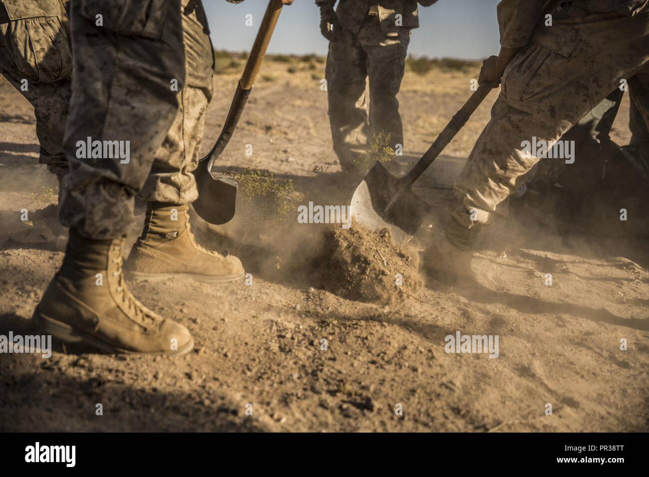 Stati Uniti Marines con Fox batteria, 2° Battaglione, xi reggimento Marine, Marine Air Ground Task force-8 (MAGTF-8) Dig un buco al posto di una M777 Obice durante la formazione integrata Esercizio (ITX) 5-17 al Marine Corps Air Ground Centro di combattimento, ventinove Palms, California, 30 luglio 2017. Lo scopo di ITX è creare un impegnativo, addestramento realistico ambiente che produce la lotta contro-pronto di forze in grado di operare come un sistema integrato di MAGTF. Foto Stock