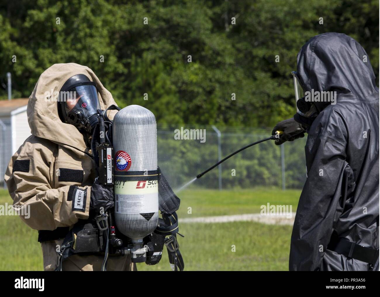 Stati Uniti Marine Corps Lance Cpl. James T. Boncore (a destra), un chimici, biologici, radiologici e nucleari (CBRN) specialista di difesa con CBRN plotone, 26 Marine Expeditionary Unit, risciacqui contaminazione nozionale off di un Marine di autorespiratori serbatoio durante la valutazione e la gestione delle conseguenze (ACM) esercizio di Camp Lejeune, N.C., 25 luglio 2017. Il team di ACM condotta sensibile allo sfruttamento del sito durante un basate su uno scenario di pre-distribuzione evento di formazione guidato da combattimento regionale di sostegno logistico ad est al fine di perfezionare le loro competenze utilizzando la squadra di ricognizione smontata set, Foto Stock