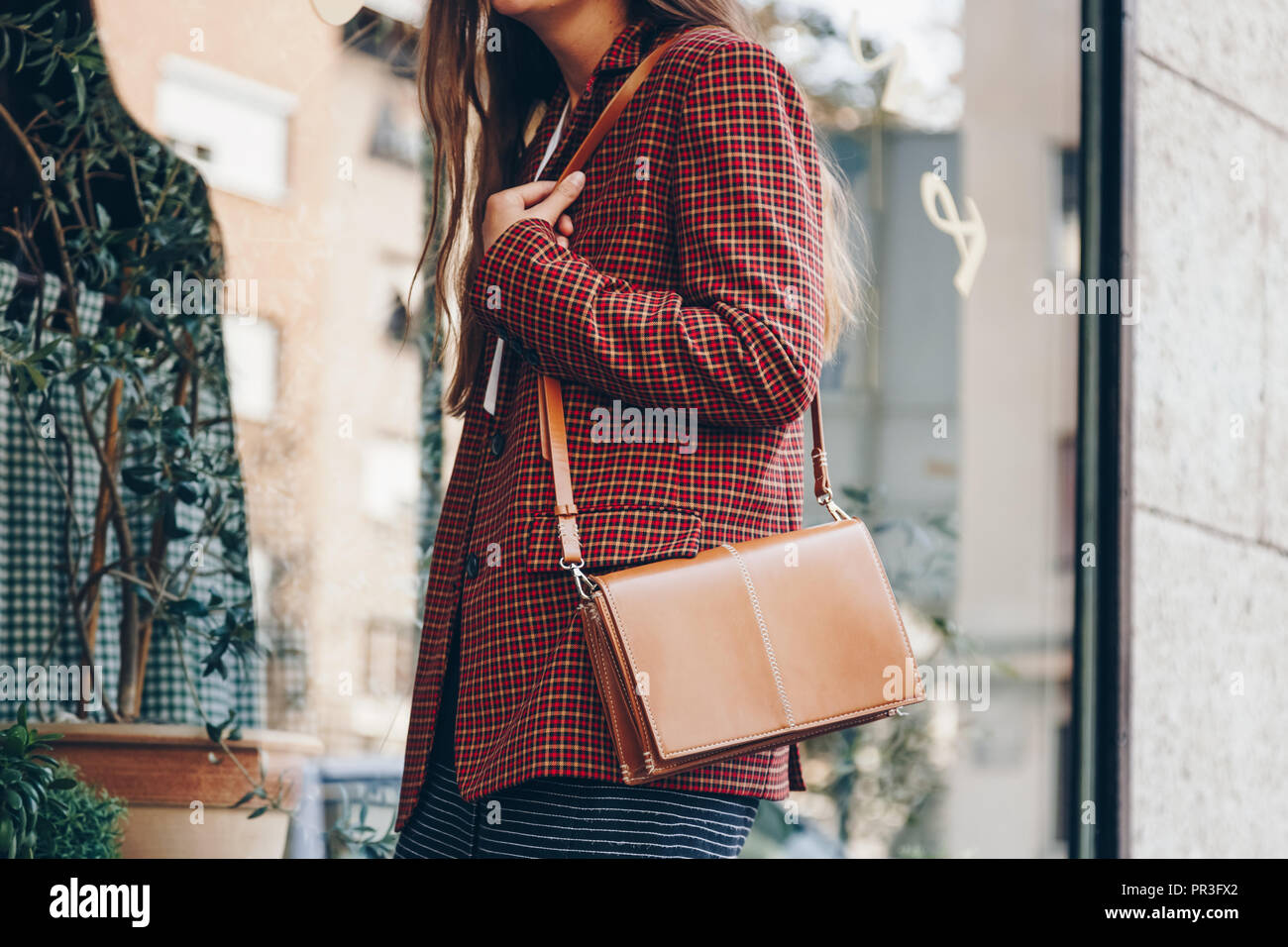 Street style, donna attraente indossa una minigonna, controllare plaid  blazer e una pelle marrone tote bag. fashion outfit perfetto per l'autunno  Foto stock - Alamy