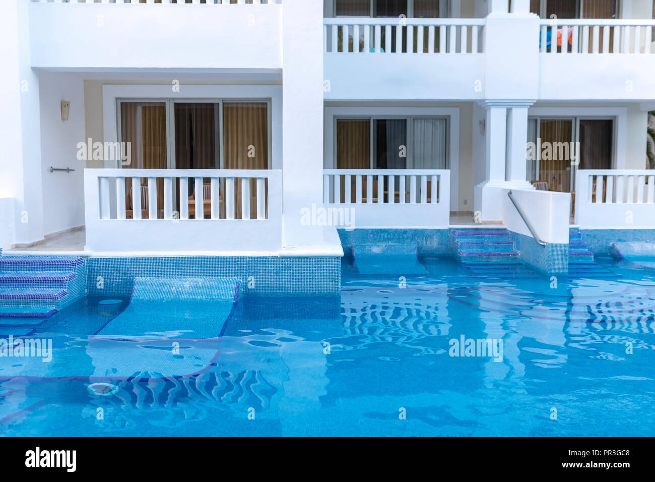 Bassa vista prospettica di un lusso tropical all inclusive hotel con balconi e una piscina a nuotare in un hotel in Messico Foto Stock