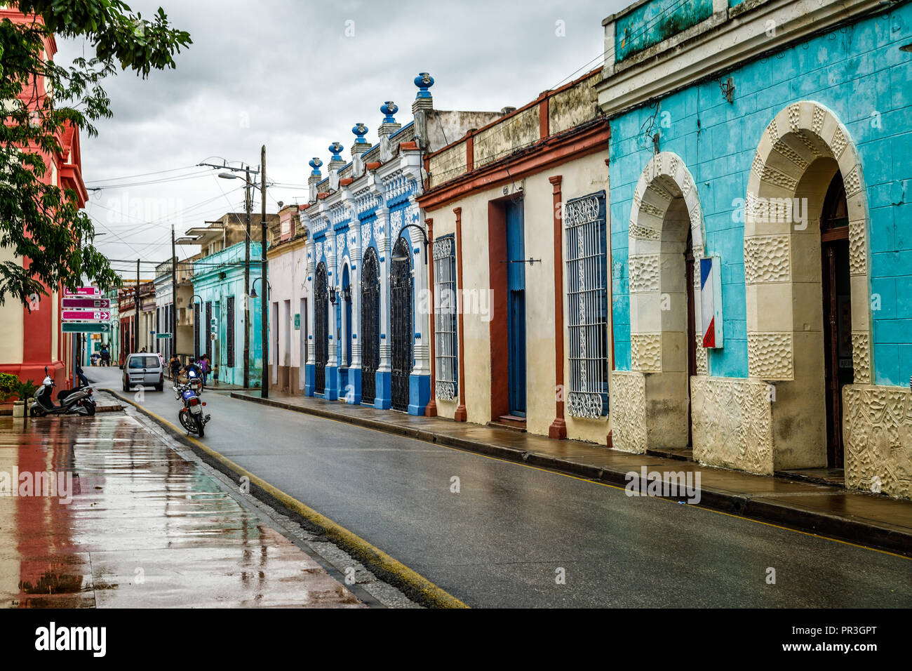 Vecchio stile coloniale spagnolo decorate colorate abitazioni lungo la strada bagnata dopo la pioggia nel centro di Camaguey, Cuba Foto Stock
