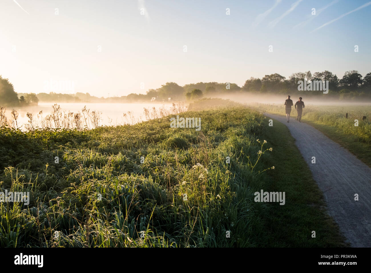 La mattina presto guide. Due persone che costeggia il fiume Trent, Nottinghamshire, England, Regno Unito Foto Stock