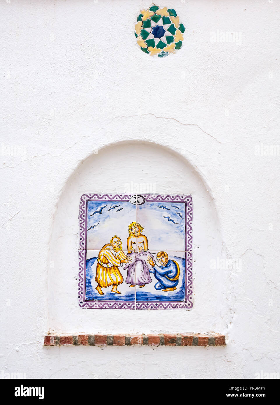 Colorate piastrelle di ceramica sulla parete raffiguranti la fede cattolica decima stazione della croce, Salares, Axarquia, Andalusia, Spagna Foto Stock