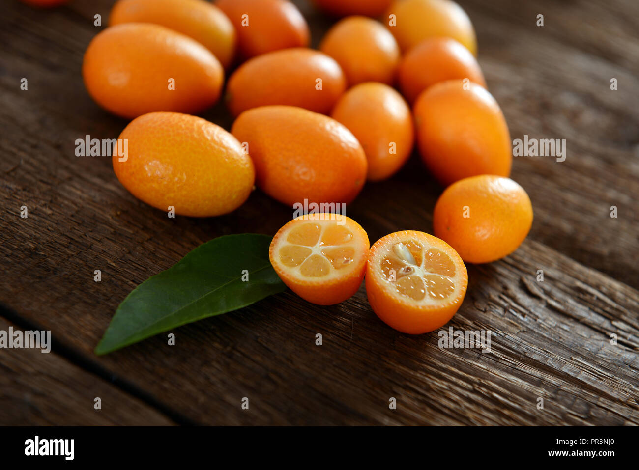 Kumquat frutti sul vecchio tavolo in legno Foto Stock