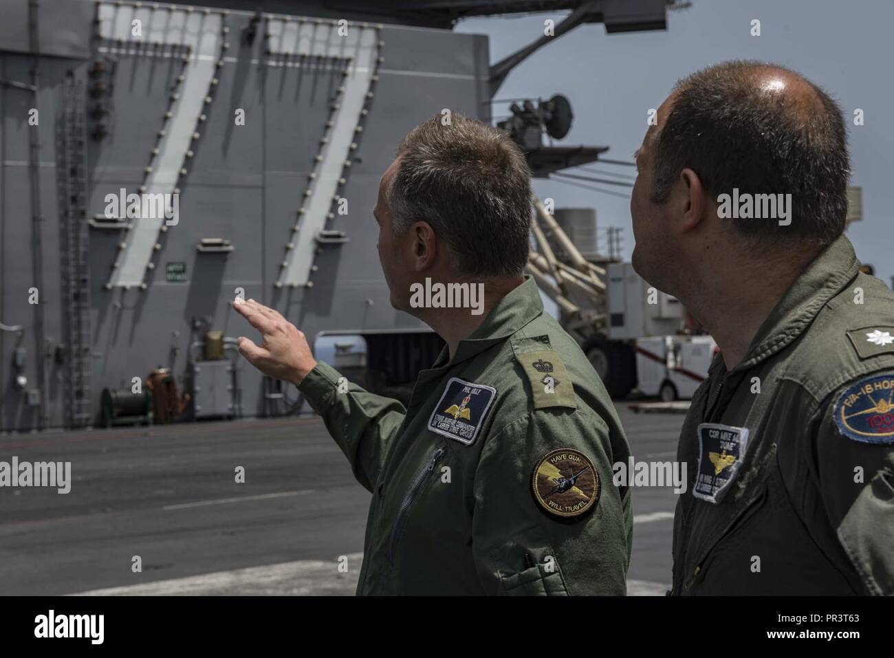 Mare Mediterraneo (Luglio 22, 2017) Royal Marines Lt. Col. Phil 'Royal' Kelly e U.S. Navy Cmdr. Mike 'dome' Mullen, scambio ufficiale con la U.K. Carrier Strike gruppo, parlare di struttura dell'isola sul ponte di volo della portaerei USS George H.W. Bussola (CVN 77). Gli ufficiali sono impegnati nella preparazione per esercizio guerriero sassone, un esercizio di keystone come il Regno Unito si prepara per l'arrivo dell'HMS Queen Elizabeth. Il GHWB e la sua portante strike gruppo stanno conducendo operazioni militari negli Stati Uniti Sesta flotta area di operazioni a sostegno degli Stati Uniti per gli interessi di sicurezza nazionali in euro Foto Stock