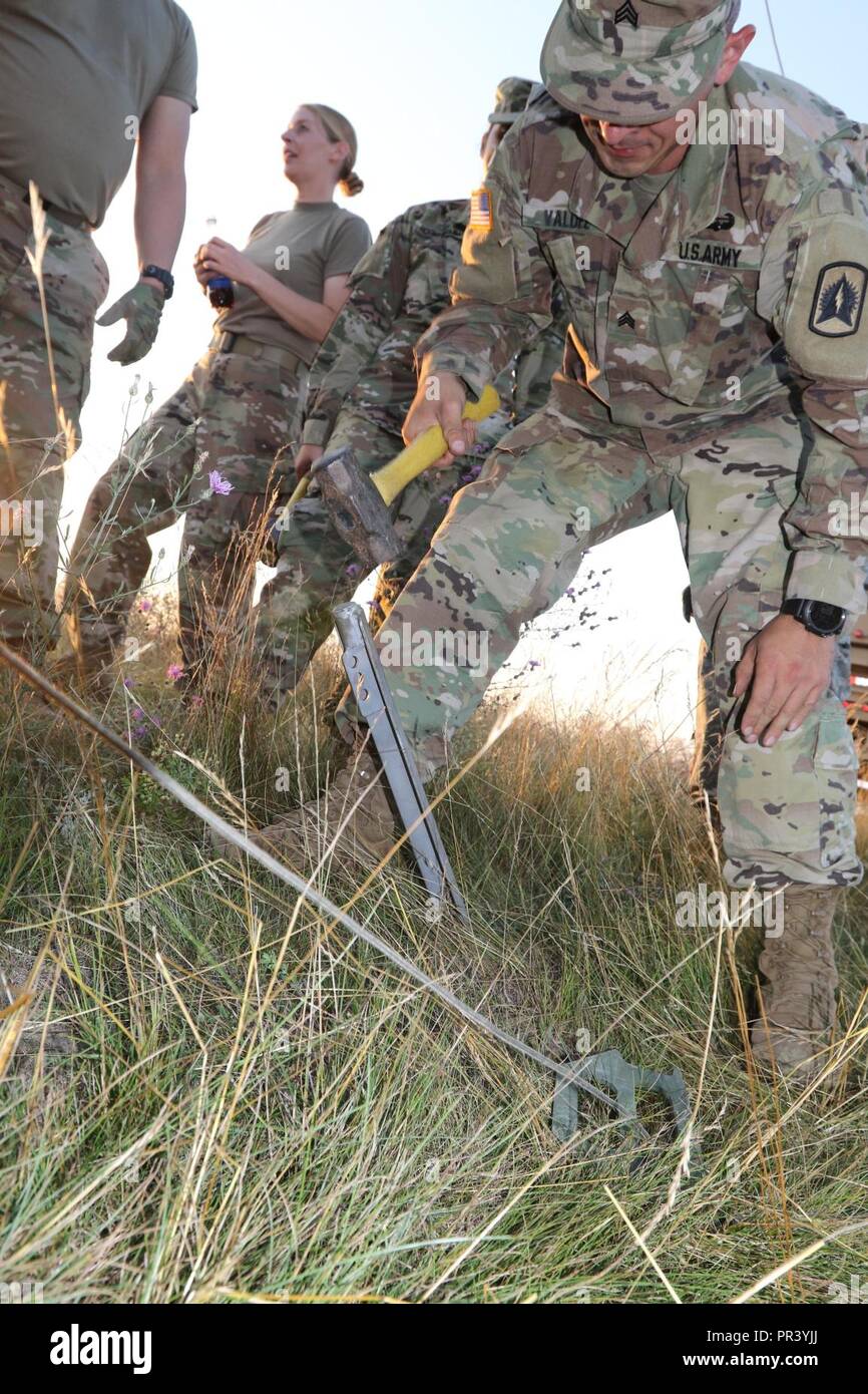 Army Sgt. Edgar Valdez, un soldato nel 3° Battaglione, 265la difesa aerea reggimento di artiglieria, martelli in pali che sarà utilizzato per fissare il antennea per loro rader tracking system a Camp Temolo Airfield Base durante il funzionamento sciopero settentrionale, luglio30, 2017. Funzionamento sciopero settentrionale è di due settimane di esercizio che valuta la conoscenza del funzionamento di aria-terra di forze tra l'U.S.esercito, l'aeronautica e le unità marine da tutto il paese, come pure, lettone, Gran Bretagna, e lucidare il personale militare. Foto Stock