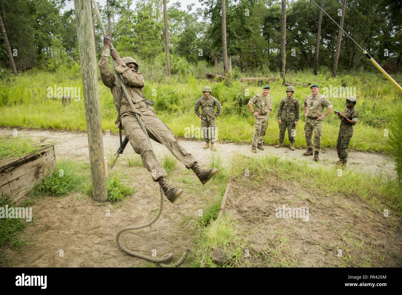 Stati Uniti Marines e British Royal Marine Commando guarda come una recluta della società Eco, 2a reclutare battaglione di formazione, oscilla su una fune su un combattimento endurance corso Luglio 29, 2017, sull isola di Parris, S.C. I leader del commando Training Center Royal Marines visitato Parris Island a guardare come U.S. Le reclute Marine sono addestrati. Foto Stock