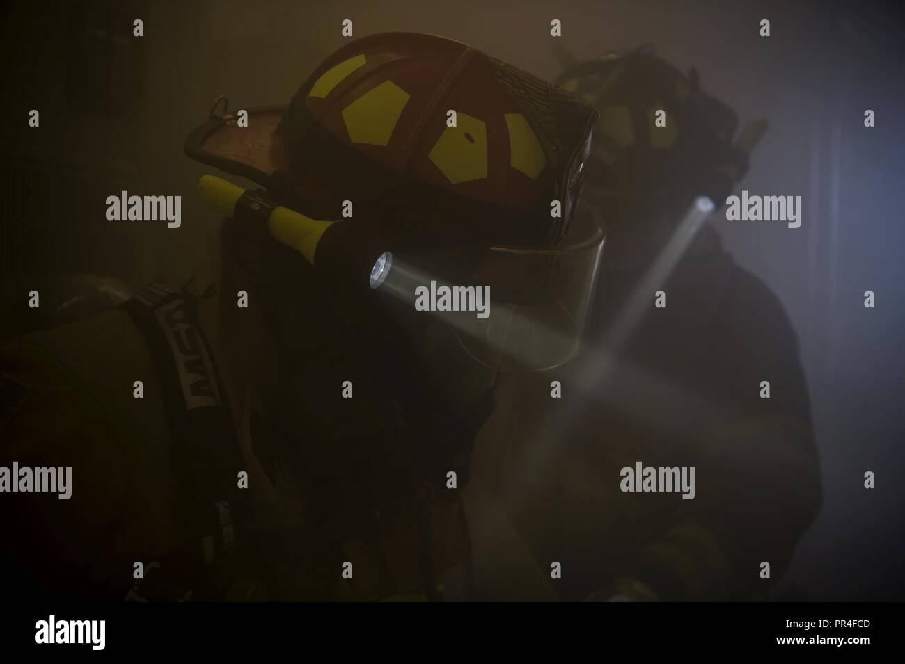 Stati Uniti Air Force Staff Sgt. Xavier Fattorie, 52nd ingegnere civile squadrone di rivelazione incendio capo equipaggio, sinistra e Senior Airman Kyler Tiebout, 52nd CES pompiere, destra inserire una masterizzazione simulata edificio a Spangdahlem Air Base, Germania, Sett. 12, 2018, durante una base-ampia disponibilità di esercizio. Il dipartimento dei vigili del fuoco ha risposto dopo una simulazione di attacco chimico. Disponibilità successo necessario aviatori per identificare e risolvere i problemi in modo rapido, disciplinata la moda. Foto Stock