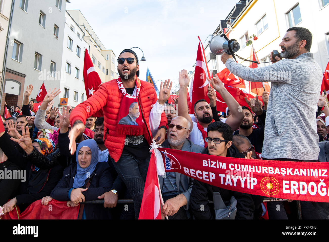 29 settembre 2018, della Renania settentrionale-Vestfalia, Colonia: Erdogan seguaci sventolando bandiere e rasserenanti intorno la Ditib Moschea centrale. La moschea è ad essere inaugurato sabato dal Presidente turco Erdogan. Erdogan è su una tre giorni di visita di Stato in Germania. Foto: Marius Becker/dpa Foto Stock