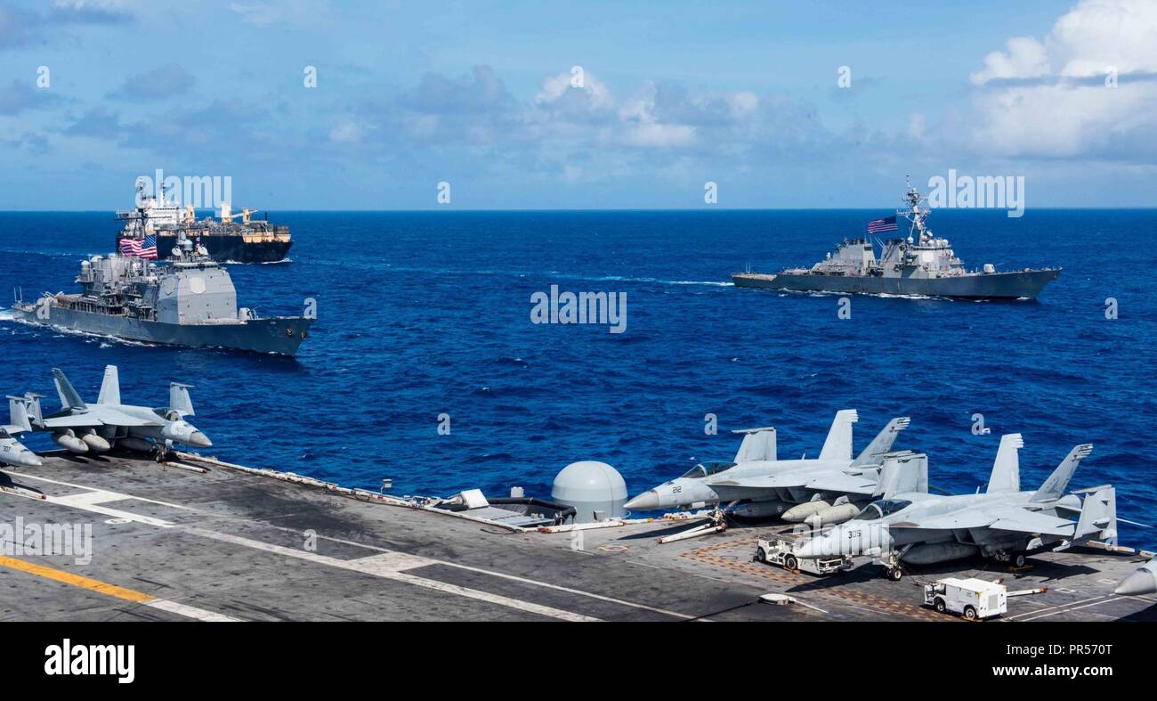 Mare delle Filippine (sett. 17, 2018) La portaerei USS Ronald Reagan (CVN 76) conduce il Ronald Reagan Strike gruppo durante un esercizio di foto per valoroso scudo 2018, raffigurato con Ticonderoga-class missile cruiser USS Chancellorsville (CG 62), il Arleigh Burke-class guidato-missile destroyer USS Benfold (DDG 65) e USNS 2 Lt. John P. Bobo (T-AK 3008). La biennale, SOLO NEGLI STATI UNITI, campo-esercizio di formazione si concentra sull'integrazione di formazione congiunta tra Stati Uniti Navy, Air Force e Marine Corps. Questo è il settimo esercizio nel Valiant scudo serie che ha avuto inizio nel 2006. Foto Stock