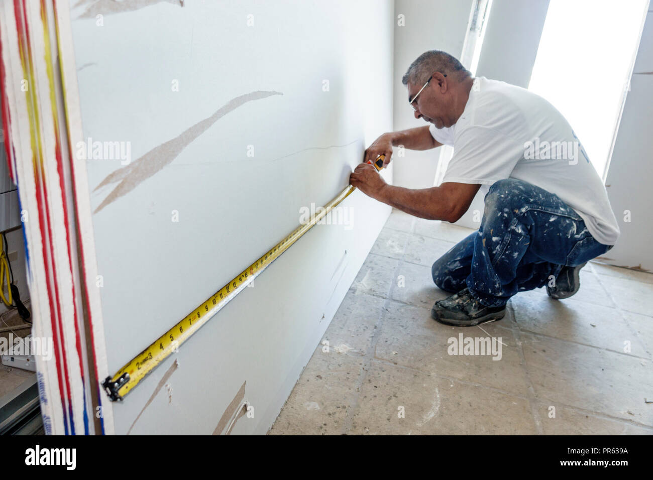 Miami Beach Florida,appaltatore,ristrutturazione,riparazione,muro a secco,uomo ispanico maschio,metro a nastro di misurazione,taglio,lavoro,FL180630007 Foto Stock