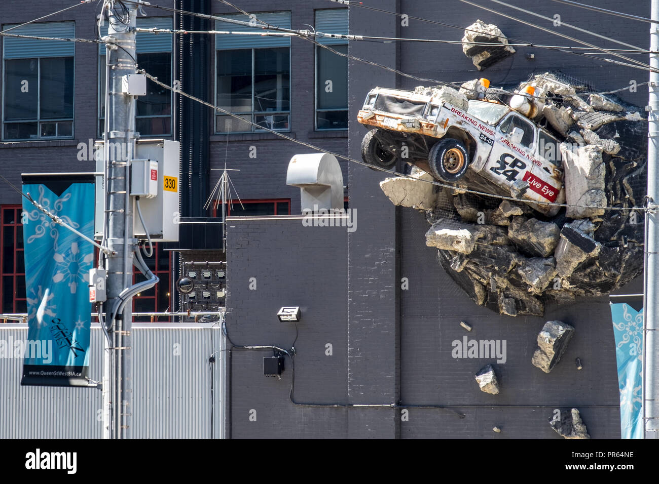 Un pezzo di arte di strada raffigurante un broadcast news scoppio del veicolo fuori della parete della campana Media HQ nel centro cittadino di Toronto Foto Stock