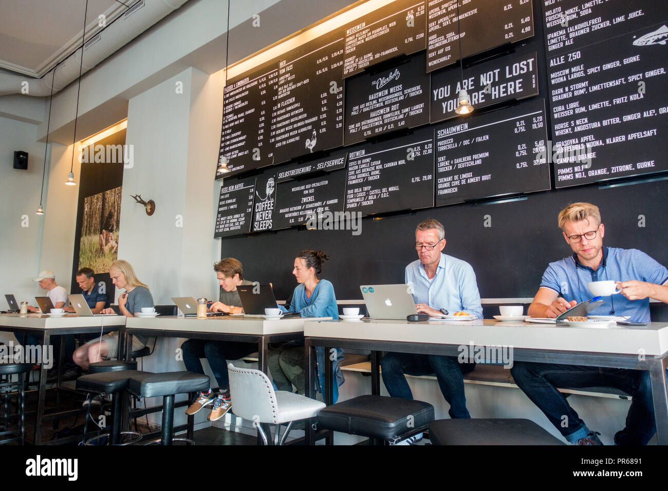 La gente che lavora sul computer portatile in un cafe in Berlin Mitte area Foto Stock