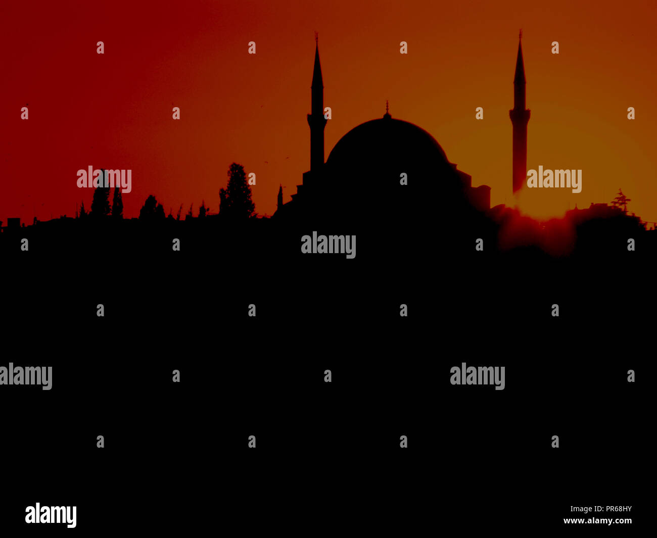 Silhouette di una moschea delineato dal rosso infuocato tramonto Foto Stock
