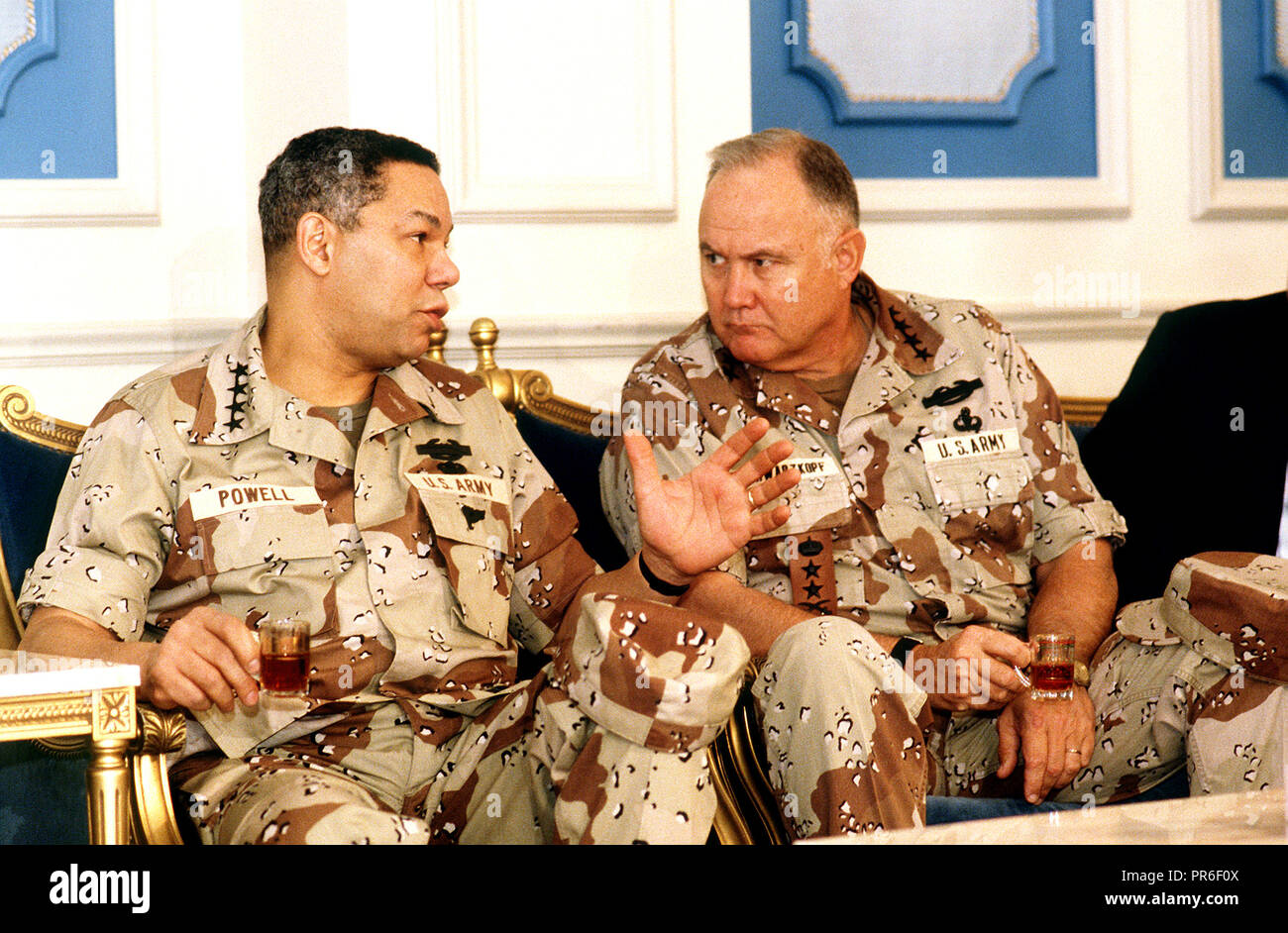 Generale Norman H. Schwarzkopf, commander-in-chief, U.S. Comando centrale, si consulta con il presidente del Comune di capi di Stato Maggiore Generale Colin Powell come gli uomini prendere parte a una riunione in merito militare alleata coalizione durante operazione Desert Shield. Foto Stock