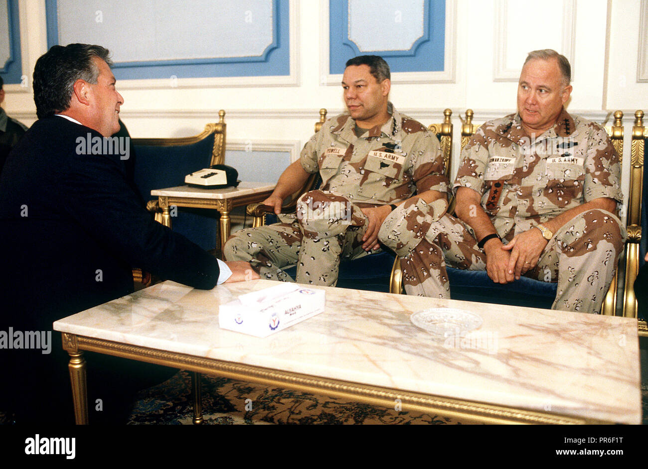 Charles Freeman, ambasciatore degli Stati Uniti in Arabia Saudita, conversa con il presidente del Comune di capi di Stato Maggiore gen. Colin Powell e gen. Norman H. Schwarzkopf, commander-in-chief, U.S. Il comando centrale. Gli uomini stanno prendendo parte a una riunione in merito militare alleata coalizione durante operazione Desert Shield. Foto Stock