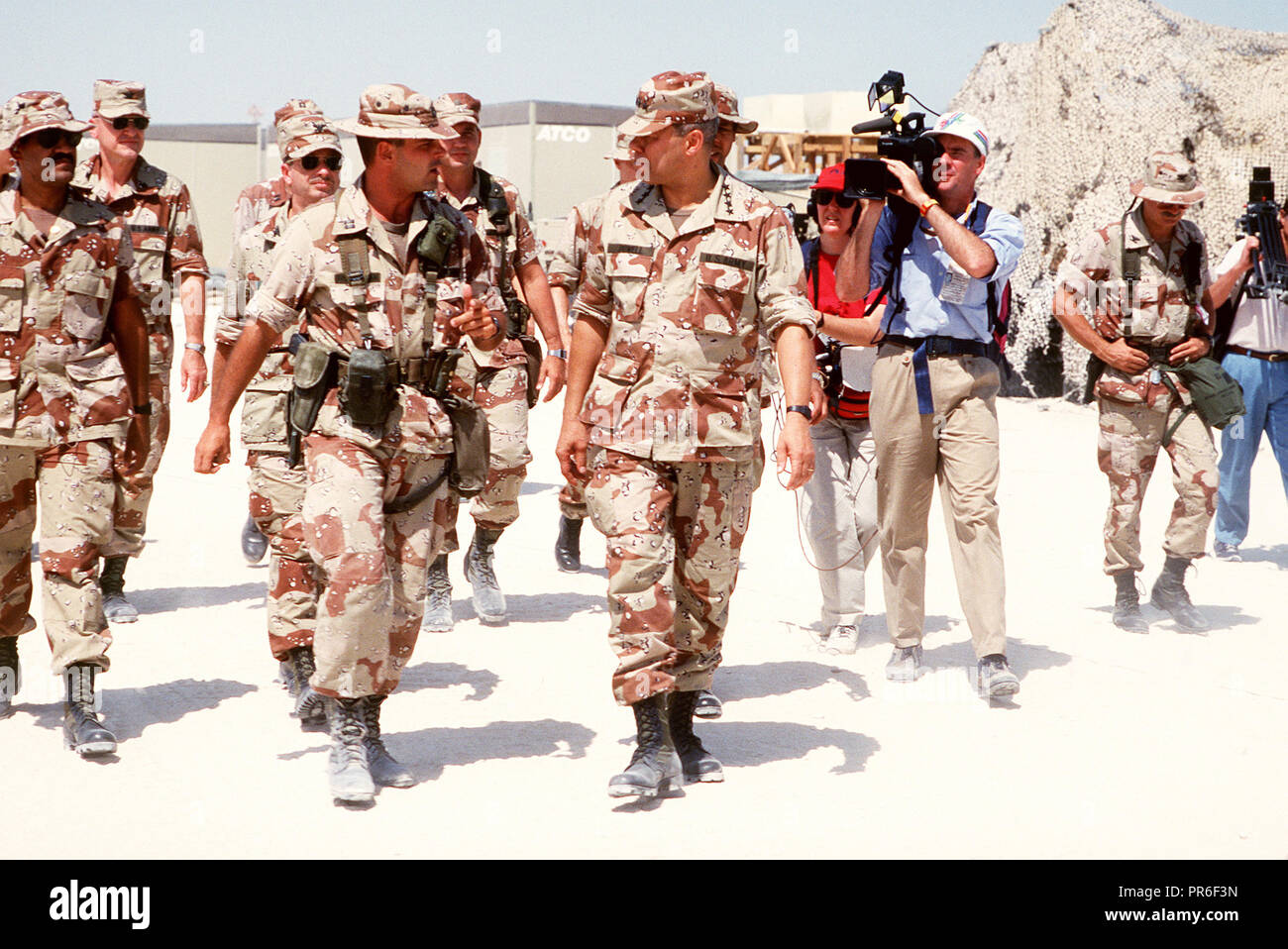 Media film camermen General Colin Powell, presidente del Comune di capi di Stato Maggiore, come egli tours strutture militari durante operazione Desert Shield. Foto Stock