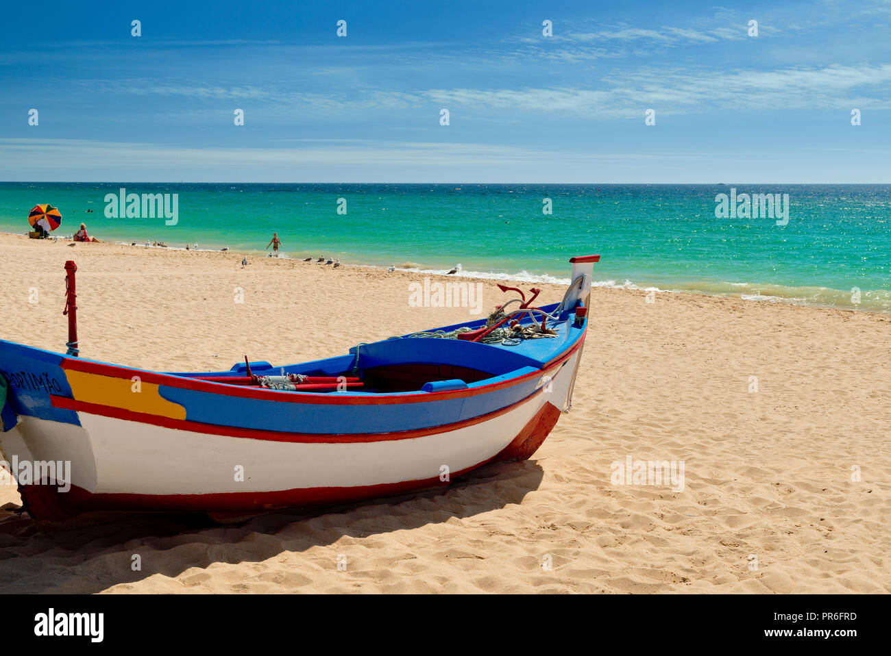 Barca da pesca dipinte in colori tradizionali, su Armacao de Pera beach Foto Stock