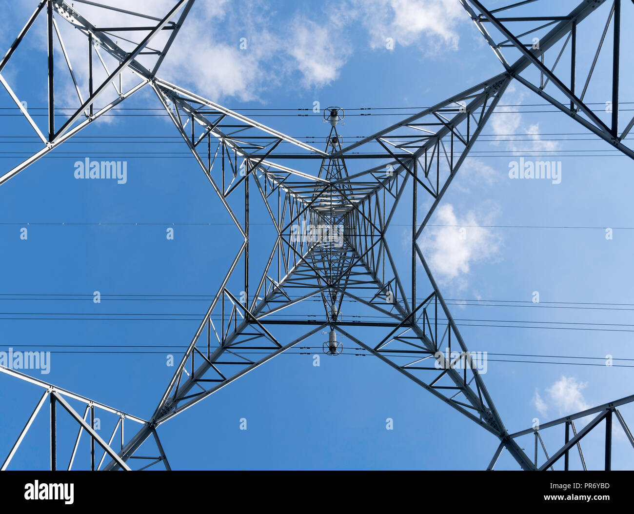 Guardando verticalmente verso l'alto dal centro di una distribuzione di elettricità pilone, England, Regno Unito Foto Stock