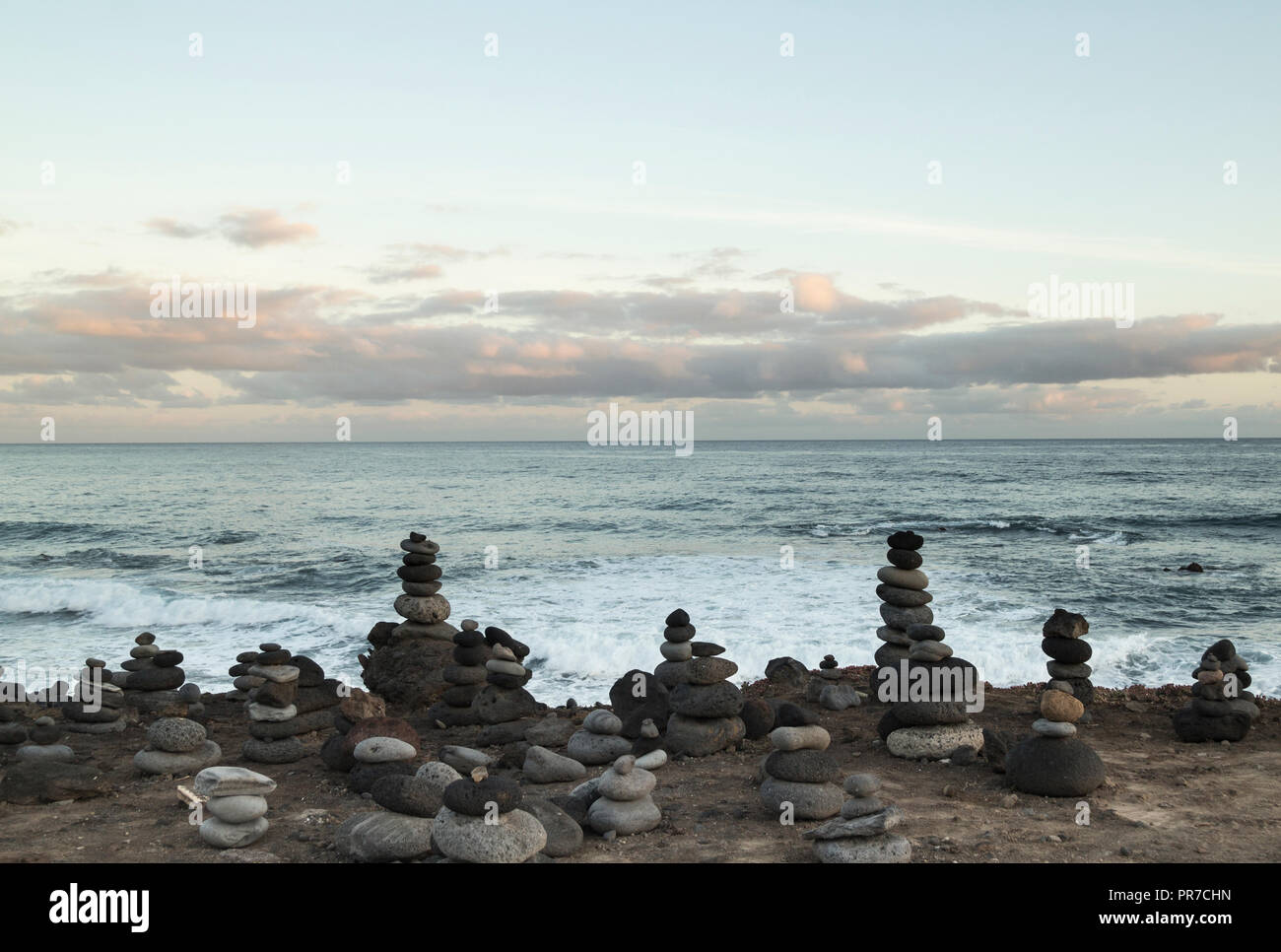 Pietre bilanciato/impilamento di pietra sulla spiaggia rocciosa. Foto Stock